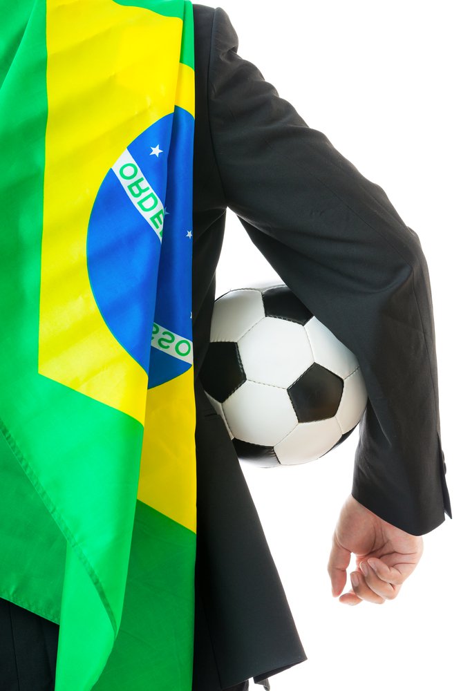 FIFA World Cup 2014 depicted by man wearing Brazilian flag and holding a football