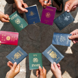 Exchange students holding passports to depict MBA colleges in India with best international tie ups